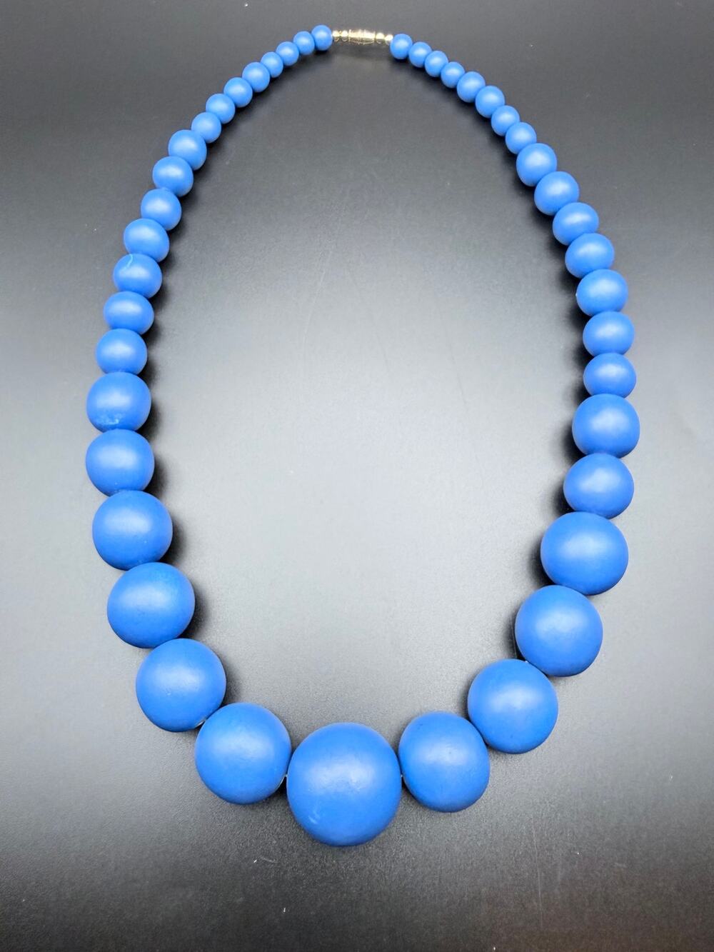 Vintage chunky blue wood beaded necklace with a gradual bead size design
